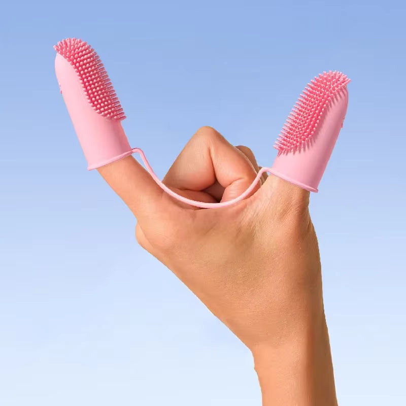 Pink silicone pet finger toothbrushes on hand